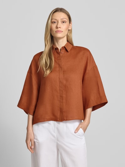 Frauenmodel trägt Boxy Fit Leinenbluse mit 3/4-Arm Modell 'RITO' von MM by Max Mara in Rostbraun, Hemdblusenkragen, verdeckte Knopfleiste, reine Leinenstruktur, Rückenlänge bei Größe 36: 58 cm, Ärmellänge 27 cm, Ganzkörperansicht von vorne.
