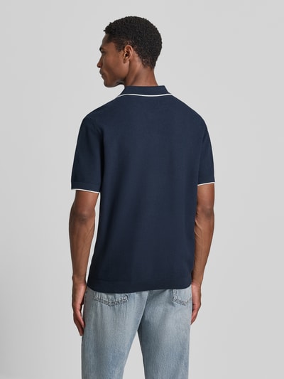 Männermodel trägt Regular Fit Poloshirt mit Kontrastkante von Christian Berg Men, Reine Baumwolle, Strukturmuster, Ganzkörperansicht Rückansicht.