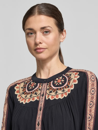 Frauenmodel trägt Relaxed Fit Bluse mit Rundhalsausschnitt Modell 'VALDA' von Bash aus reiner Viskose im Allover-Look, Nahaufnahme Oberkörper.