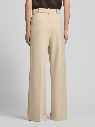 Frauenmodel trägt Wide Fit Stoffhose mit Viskose-Anteil Modell 'Paris' von Mango in Beige mit Bügelfalten, Ganzkörperansicht Rückansicht.