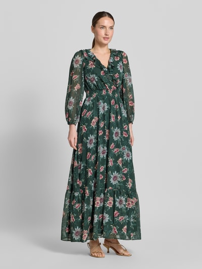 Frauenmodel trägt Maxikleid mit Volantsaum und V-Ausschnitt von Zero, grün mit Blumenmuster, Taillierter Schnitt, Rüschen, Smok-Detail, blickdichtes Unterkleid, elastische Ärmelabschlüsse, Ganzkörperansicht von vorne.