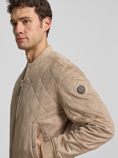 Männermodel trägt Jacke mit Steppnähten Modell 'Ronan' von JOOP! Collection in Beige, Material-Mix mit Stretch-Anteil, Nahaufnahme Oberkörper.