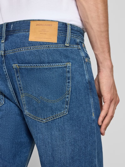Mężczyzna nosi Straight Fit Jeans aus Baumwoll-Mix Modell 'CHRIS' von JACK & JONES, mieszanka bawełny, 5 kieszeni, niebieski denim, zapięcie na guzik i zamek błyskawiczny, szerokość w rozmiarze 32/32: 41 cm, długość wewnętrzna nogawki: 72 cm, detal tył, zbliżenie górnej części spodni