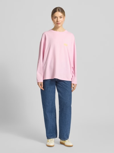 Frauenmodel trägt Longsleeve mit Label-Print Modell 'GIXY' von American Vintage in Rosa aus Reine Baumwolle, Relaxed-Fit, Rundhalsausschnitt; Rückenlänge bei Größe XS/S 64 cm, Ganzkörperansicht von vorne.