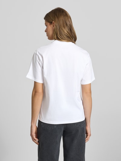 Frauenmodel trägt Damen T-Shirt mit Label-Stitching von Carhartt Work In Progress aus reiner Bio-Baumwolle, Relaxed-Fit, Rückenlänge 64 cm, Rundhalsausschnitt, Ganzkörperansicht Rückansicht.