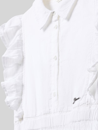 Mädchen trägt Knielanges Kleid mit Schmetterlingsärmeln von Guess aus weißem Baumwoll-Mix mit Kentkragen, Label-Detail, Rock mit Häkelspitze, taillierter Schnitt, Nahaufnahme Oberkörper.