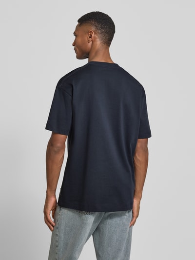 Männermodel trägt Relaxed Fit T-Shirt aus reiner Baumwolle von Marc O'Polo in Dunkelblau, unifarben, kurzarm, Feinripp, Ganzkörperansicht Rückansicht.