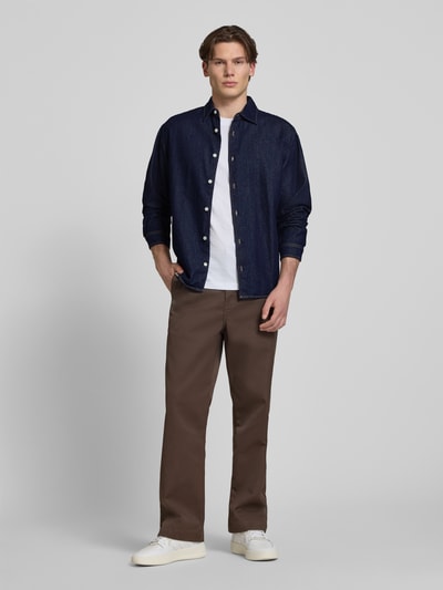 Männermodel trägt Regular Fit Jeanshemd mit Kentkragen Modell 'NORREBRO' von Jack & Jones aus reiner Baumwolle, Ganzkörperansicht von vorne. Rückenlänge bei Größe M 74 cm, Schulterbreite 46 cm, Ärmellänge 61 cm, Hemd in dunklem Blau mit Knopfleiste und glatter Textur.