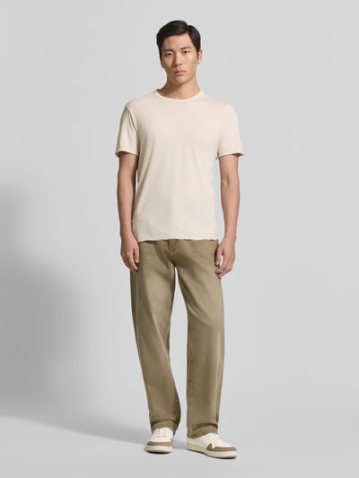 Männermodel trägt Regular Fit T-Shirt mit Rundhalsausschnitt Modell 'Devon' von American Vintage in Creme zu beigen Hosen, Ganzkörperansicht von vorne. Reine Baumwolle, Rückenlänge bei Größe M: 71 cm.