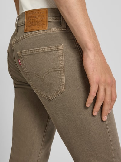 Männermodel trägt Slim Fit Jeans aus Baumwoll-Mix Modell '511® SLIM' von Levi's® in Beige, strukturierte Oberfläche, Nahaufnahme Rückansicht.