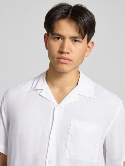 Männermodel trägt weißes Relaxed Fit Freizeithemd aus Leinen-Viskose-Mix Modell 'LAURENCE' von Only & Sons, Optik: Unifarben, Passform: Relaxed-Fit, Hemdkragen: Reverskragen, Knopfleiste: Einreihig, Ärmelform: Kurzarm, Brusttasche, Nahaufnahme Oberkörper.