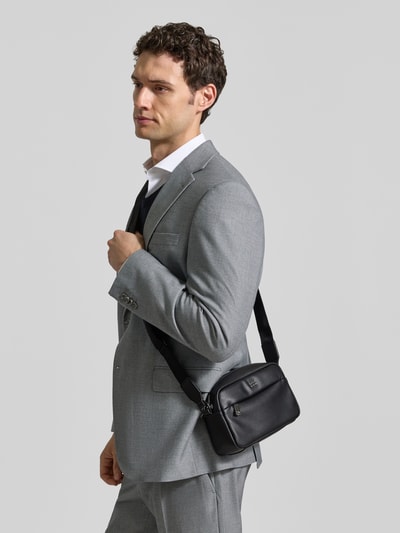Męski model nosi czarno-szarą torbę na ramię z detalem z logo, Umhängetasche mit Label-Detail Modell 'Ray EVO_EW Crossbody' od BOSS, Ganzkörperansicht z przodu, Herren Umhängetasche von BOSS.