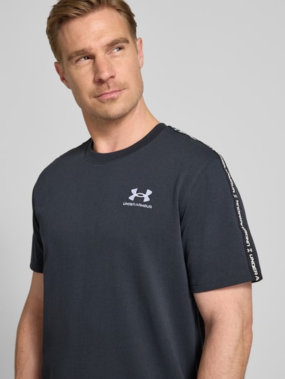 Männermodel trägt Regular Fit T-Shirt mit Logo-Stitching Modell 'Icon' von Under Armour aus Baumwoll-Mix, Nahaufnahme Oberkörper.