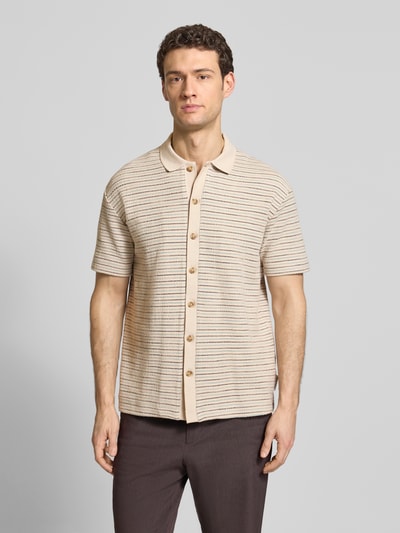 Männermodel trägt Relaxed Fit Poloshirt aus reiner Baumwolle von JOOP!, unifarben, mehrfarbig gestreift, Crinkle-Struktur, Ganzkörperansicht von vorne.