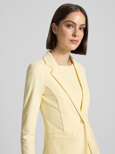 Frauenmodel trägt Slim Fit Blazer mit Paspeltaschen Modell 'KATE' von ICHI in Hellgelb, Baumwoll-Mix mit Stretch-Anteil, Nahaufnahme Oberkörper.