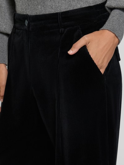 Vrouwenmodel draagt zwarte corduroy broek met steekzakken van windsor., mix van katoen en elastaan, wijde benen, elastische band, detailopname.