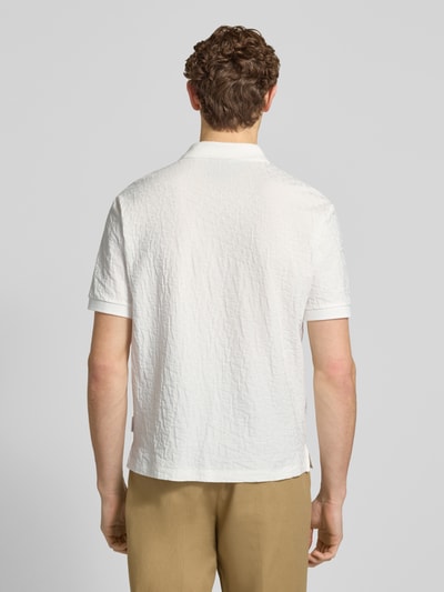 Männermodel trägt Regular Fit Poloshirt mit Strukturmuster von ARMANI EXCHANGE aus reiner Baumwolle, Rückenlänge 68 cm, Ganzkörperansicht Rückansicht.