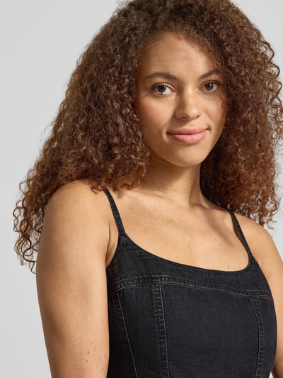 Frauenmodel trägt Tailliertes Jeanskleid aus reiner Baumwolle Modell 'JADINE' von Levi's® in schwarzer Denim-Optik mit Karree-Ausschnitt, Label-Patch, verstellbaren Spaghettiträgern, Mini-Länge, Nahaufnahme Oberkörper.