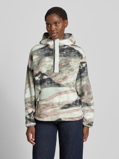 Vrouwenmodel draagt Hoodie met Label-Patch model 'Helvetia' van Columbia, fleece, straight fit, kap, korte drukknoopsluiting, zijritszakken, meerkleurige tinten in beige, grijs en groen, zachte textuur, voorkant geheel zichtbaar, Ganzkörperaanzicht van voren.