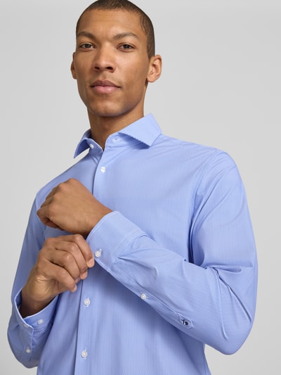 Männermodel trägt Slim Fit Business-Hemd mit Haifischkragen von SEIDENSTICKER, Material-Mix mit Stretch-Anteil, Nahaufnahme Oberkörper.