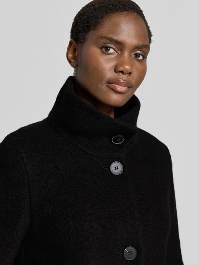 Frauenmodel trägt Regular Fit Jacke aus Woll-Mix von FUCHS SCHMITT in Schwarz mit Stehkragen und Knopfleiste, Nahaufnahme Oberkörper. Damenjacke mit Eingrifftaschen, Schulterbreite 44 cm, Brustweite 51 cm, Ärmellänge 64 cm, Rückenlänge 82 cm.