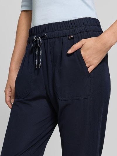 Frauenmodel trägt Hose mit elastischem Bund und Eingrifftaschen von Marc Cain, Dunkelblau, Material-Mix mit Stretch-Anteil, Nahaufnahme Oberkörper.