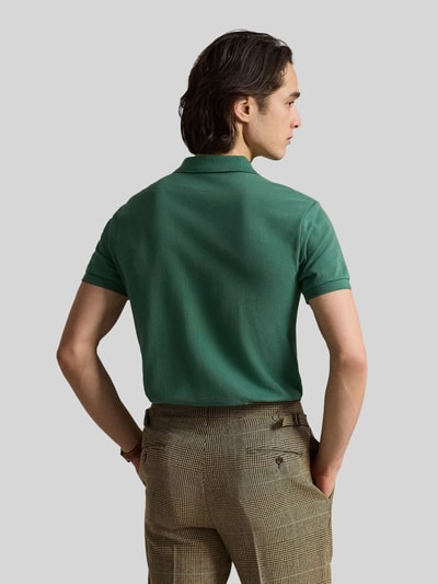 Männermodel trägt Regular Fit Poloshirt aus reiner Baumwolle von Polo Ralph Lauren in Uni-Grün, Piqué-Struktur, Ganzkörperansicht Rückansicht.