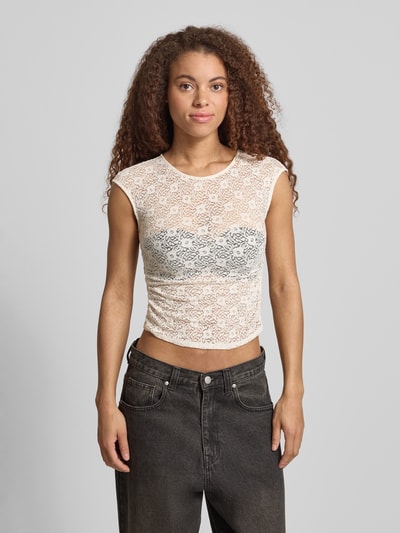 Frauenmodel trägt T-Shirt aus Spitze mit Raffung an der Seitennaht von REVIEW in Creme, elastischer Material-Mix, Nahaufnahme Oberkörper.