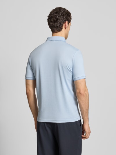 Mężczyznа nosi Slim Fit Poloshirt mit Label-Detail von HECHTER PARIS, jasnoniebieski kolor, mieszanka bawełny, krój slim fit, kołnierzyk polo, elastyczne wykończenia, detal z logo, długość tyłu w rozmiarze M: 70 cm, całkowity widok z tyłu.