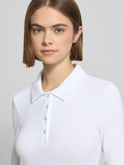 Vrouwenmodel draagt wit Slim Fit Langarmshirt uit katoenmix met polokraag en label stitching van Pieces, Nahaufnahme bovenlichaam.