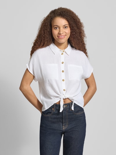 Vrouwenmodel draagt Regular Fit overhemdblouse uit viscose-linnen-mix model 'PIA' van Pieces, effen kleuren, korte mouw, knoopsluiting, rompzoom met knoopdetail, voorkantopname bovenlichaam.