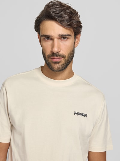 Männermodel trägt T-Shirt mit Logo und Rundhalsausschnitt von Napapijri in Beige, Baumwoll-Elasthan-Mix, krój regular fit, Nahaufnahme Oberkörper, długość pleców w rozmiarze M: 63 cm.