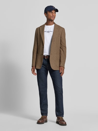Mannenmodel draagt Regular Fit T-shirt uit puur katoen van Polo Ralph Lauren, witte kleur, eenvoudige textuur, donkerblauwe jeans, Ganzkörperansicht von vorne.