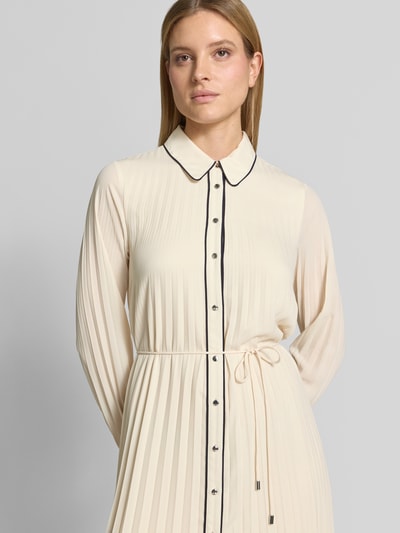 Frauenmodel trägt Regular Fit Midikleid in Falten-Optik von Comma in Creme mit schwarzen Details, Umlegekragen, Taillenband, Langärmelig, durchgängige Knopfleiste, taillierte Passform, Ganzkörperansicht von vorne. Rückenlänge bei Größe 36: 120 cm, Brustweite 50 cm, Ärmellänge 64 cm.