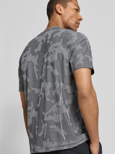 Männermodel trägt T-Shirt mit Rundhalsausschnitt und Label-Detail von EA7 Emporio Armani, regular fit, grijs met camouflagepatroon, rugaanzicht, materiaal-mix met stretch, ruglengte maat M 69 cm.