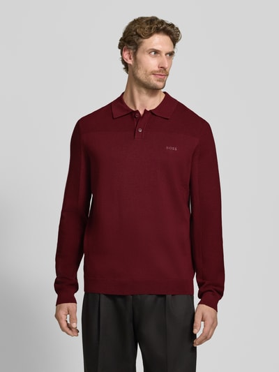 Männermodel trägt bordeauxrotes Relaxed Fit Poloshirt mit Woll-Anteil Modell 'KN_Momentum-X PL' von BOSS Green, Ganzkörperansicht von vorne.