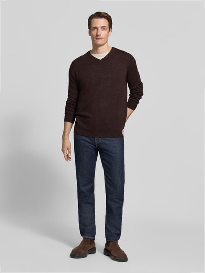 Männermodel trägt Regular Fit Strickpullover aus Baumwoll-Mix mit Kaschmir-Anteil von Fynch-Hatton in Dunkelbraun, Ganzkörperansicht von vorne. Rückenlänge 67 cm, Ärmellänge 68 cm, V-Ausschnitt, elastische Abschlüsse.