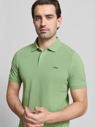 Mannelijk model draagt Regular Fit Poloshirt uit zuivere katoen van s.Oliver RED LABEL, effen lichtgroen, piquéstructuur, voorkant bovenlichaam close-up.