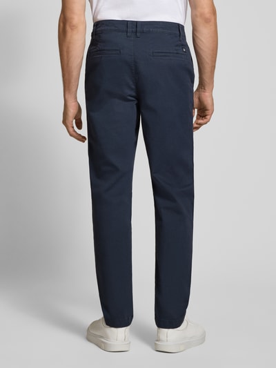 Männermodel trägt dunkelblaue Relaxed Fit Chino aus Baumwoll-Mix von Tom Tailor Denim, Herren Chino, Ganzkörperansicht Rückansicht.