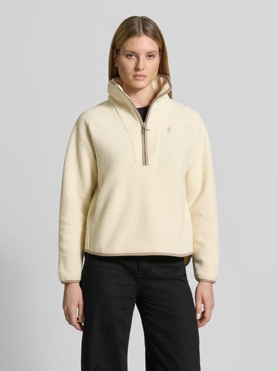 Kobiece modelka nosi Regular Fit Sweatshirt mit Stehkragen od Peak Performance, kremowa bluza, zamek błyskawiczny, wyhaftowane logo, długość tyłu w rozmiarze S: 66 cm, szerokość ramion w rozmiarze S: 45 cm, szerokość klatki piersiowej w rozmiarze S: 57 cm, długość rękawów w rozmiarze S: 60 cm, widok całej sylwetki z przodu