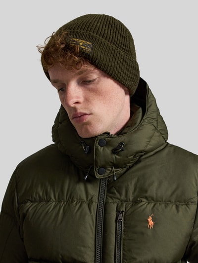 Männermodel trägt Regular Fit Daunenjacke mit Logo-Stitching von Polo Ralph Lauren in Olivgrün mit glatter Textur, Nahaufnahme Oberkörper. Herren Daunenjacke von Polo Ralph Lauren