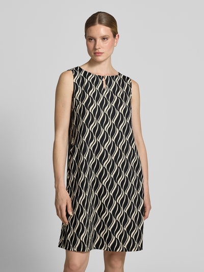 Frauenmodel trägt Knielanges Kleid mit Schlüsselloch-Ausschnitt von Betty Barclay im Material-Mix mit Stretch-Anteil, Straight Fit, schwarz-beige Muster, Knielänge, Rückenlänge 91 cm, Brustweite 44 cm bei Größe 36. Nahaufnahme Oberkörper.