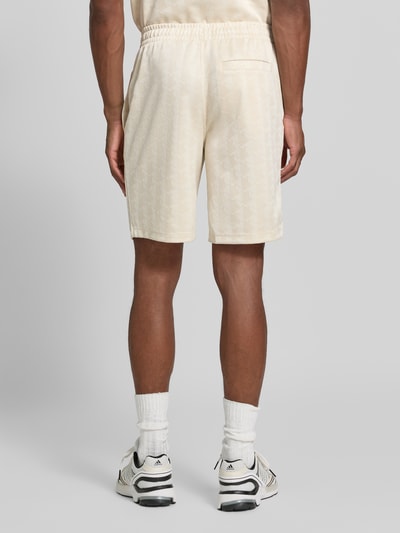 Männermodel trägt helle Regular Fit Sweatshorts mit Monogramm-Logo-Print von Lacoste, feine Textur, Herren Sweatshorts, Ganzkörperansicht Rückansicht.