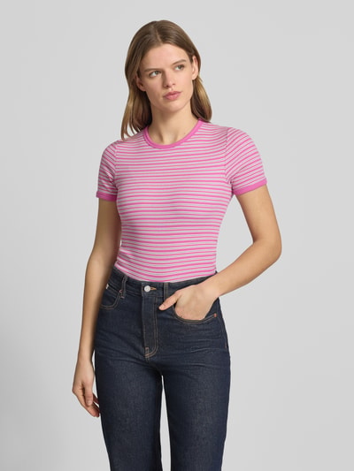 Vrouwenmodel draagt t-shirt met roze en witte strepen, nauwsluitend, mix van katoen en elastaan, model 'FRANKIE' van JJXX, ronde hals, ruglengte maat S 53 cm, pasvorm nauwsluitend, vooraanzicht van het bovenlichaam.