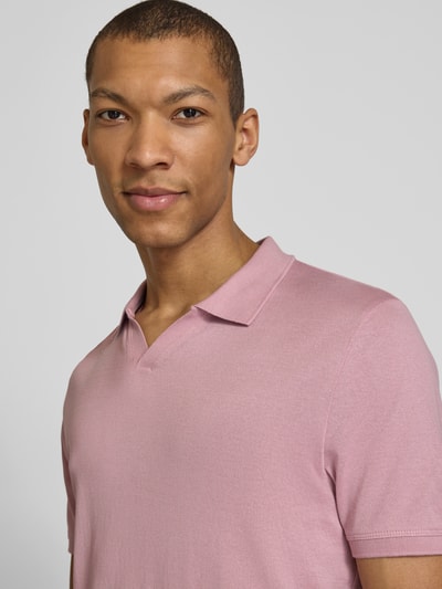 Männermodel trägt Slim Fit Poloshirt mit V-Ausschnitt Modell 'BOLL' von CINQUE in zartem Rosa, reine Baumwolle, Nahaufnahme Oberkörper.