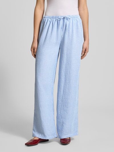 Frauenmodel trägt Pyjama Pants mit elastischem Bund von Review, Loose-Fit, blauer und weißer Streifenstoff, Ganzkörperansicht von vorne. Bundweite bei Größe S 41 cm, Innenbeinlänge 77 cm.