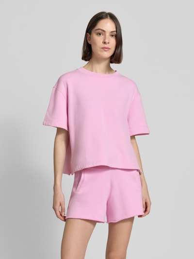 Frauenmodel trägt Oversized Sweatshirt mit 1/2-Arm von Rich & Royal aus Bio-Baumwoll-Mix mit Stretch-Anteil in Rosa, Ganzkörperansicht von vorne.