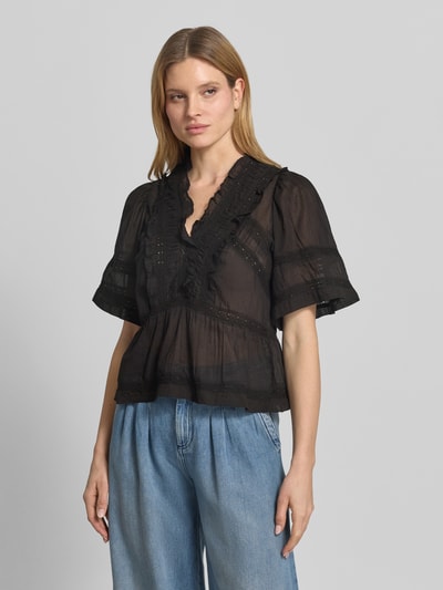 Frauenmodel trägt Blusenshirt mit Häkelspitze Modell 'Evienne' von Neo Noir, Schwarz, Reine Baumwolle, Taillierter Schnitt, V-Ausschnitt, Ganzkörperansicht von vorne.