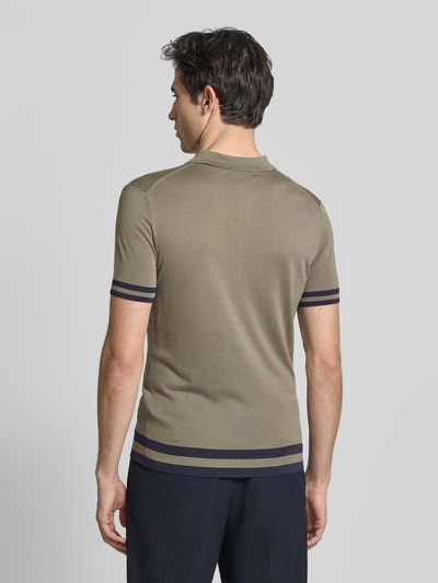 Męski model nosi Slim Fit Poloshirt aus Lyocell-Seide-Mix von GUESS, paski w kontrastowym kolorze, model 'LARRY', krój slim fit, kołnierzyk polo, listwa guzikowa, długość tyłu w rozmiarze M: 67 cm, gładka tekstura, jednolity kolor, ciemne paski na rękawach i u dołu, widok całej sylwetki od tyłu.