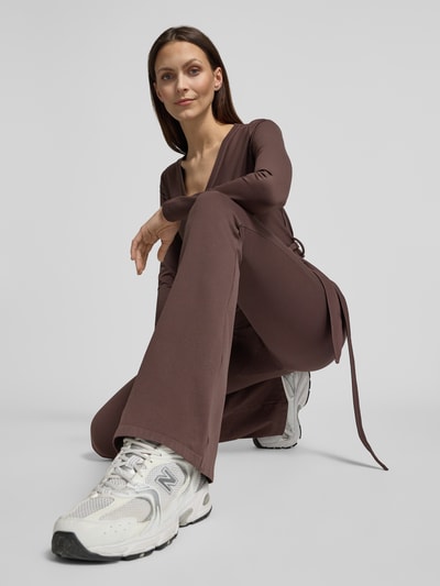 Frauenmodel trägt Flared Fit Leggins mit breitem Bund von aim'n, braun, elastischer Material-Mix, breiter Bund, Ganzkörperansicht von vorne.